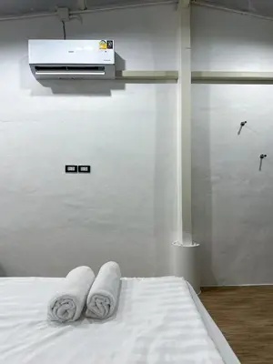 a bedroom with two towels on a bed with a heater at Megun 10 in Ban Bang Phlat