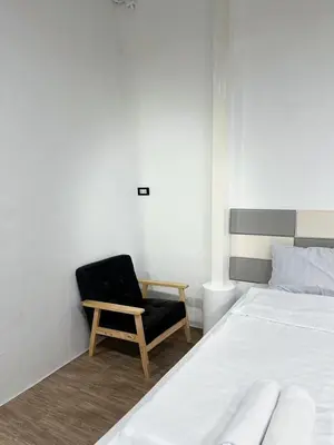 a bedroom with a black chair and a bed at Megun 10 in Ban Bang Phlat