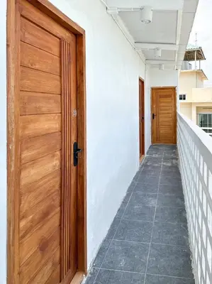 an empty hallway with a wooden door and a corridor at Megun 10 in Ban Bang Phlat