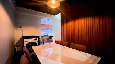 a kitchen with a white table and a red wall at uouRangnamHouse in Bangkok