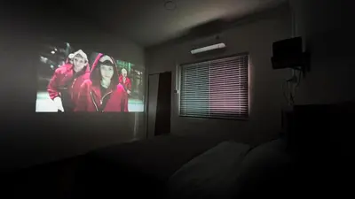 a bedroom with a tv screen in a dark room at uouRangnamHouse in Bangkok