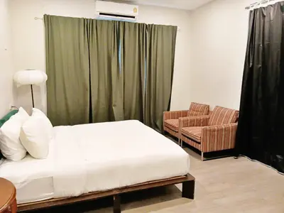 a hotel room with a bed and a chair at Hidden Dragon Yaowarat MRT วัดมังกร in Samphanthawong