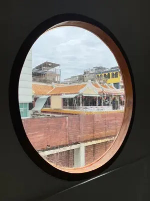 a round window with a view of a building at Hidden Dragon Yaowarat MRT วัดมังกร in Samphanthawong