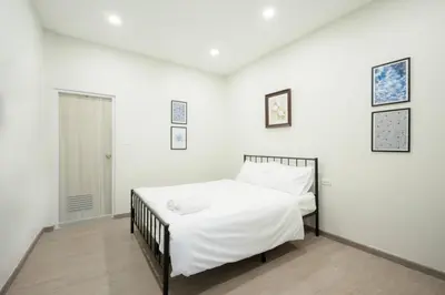 a white bedroom with a bed with white sheets at Hidden Dragon Yaowarat MRT วัดมังกร in Samphanthawong
