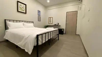 a bedroom with a bed with white sheets and a door at XX HD China Town MRT Dragon Temple in Samphanthawong