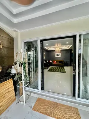a living room with a large glass door at Homemii 59 in Ban Chuat Plai Mai