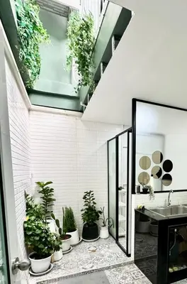 a bathroom with potted plants on the wall at Homemii 59 in Ban Chuat Plai Mai