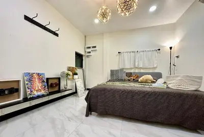 a bedroom with a large bed and a chandelier at Homemii 59 in Ban Chuat Plai Mai