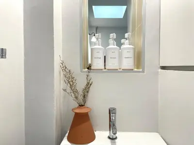 a bathroom with a sink with three bottles of soap at Vélin - Chinatown in Khlong San