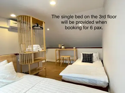 a bedroom with two beds and a bird cage on the wall at Vélin - Chinatown in Khlong San