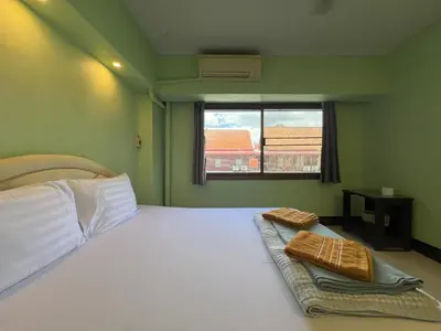 a bedroom with a bed with white sheets and a window at Bella Bella House in Bangkok