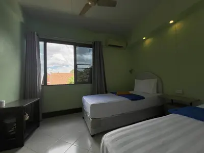 a hotel room with two beds and a window at Bella Bella House in Bangkok