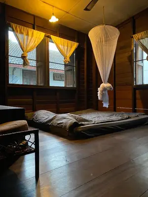 a bed in a room with windows and curtains at Chest's Place in Bangkok