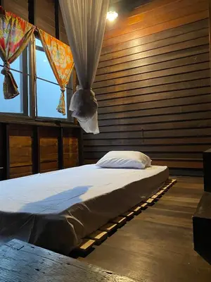 a bedroom with a bed in a room with windows at Chest's Place in Bangkok