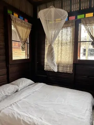a bedroom with a bed and two windows at Chest's Place in Bangkok