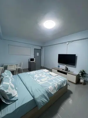 a bedroom with a large bed and a flat screen tv at KPP Mansion in Amphoe Phra Khanong