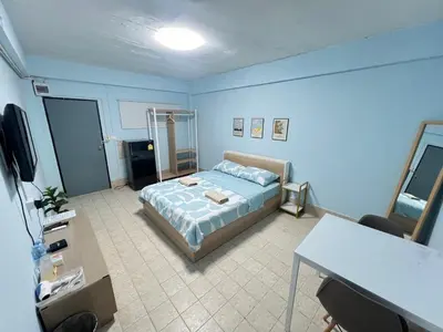 a bedroom with a bed and a table in it at KPP Mansion in Amphoe Phra Khanong