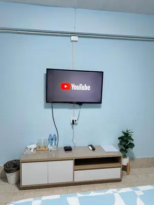 a tv hanging on a wall in a room at KPP Mansion in Amphoe Phra Khanong