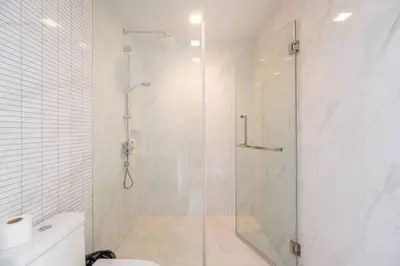 a white bathroom with a shower and a toilet at 2 BR Suite at BTS NANA Sukhumvit 11 Floor 15 Pool not permitted in Bangkok