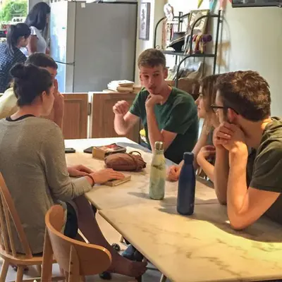 a group of people sitting around a table at Good Day Hostel in Bangkok