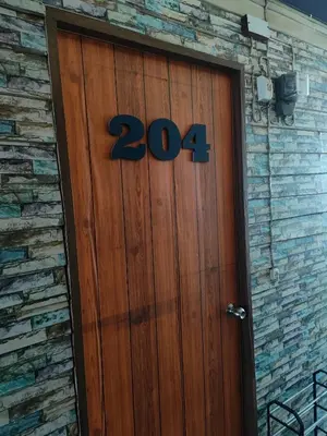a wooden door with the number on it at 204 Olan Place Spacious Studio with Wi-fi near BTS Skytrain in Bangkok