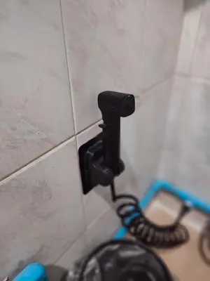 a black hose is attached to a tiled wall at 204 Olan Place Spacious Studio with Wi-fi near BTS Skytrain in Bangkok