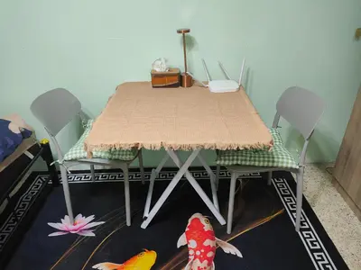 a dining room table with two chairs and a table with two toy fish at Spacious Studio with Private kitchen near Skytrain in Bangkok