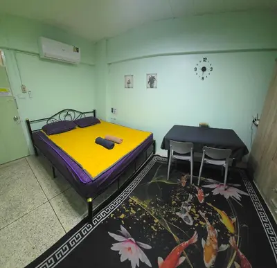 a bedroom with a bed and two chairs in it at Spacious Studio with Private kitchen near Skytrain in Bangkok