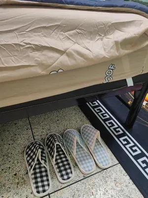 two pairs of shoes sitting under a bed at Spacious Studio with Private kitchen near Skytrain in Bangkok