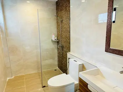 a bathroom with a toilet and a glass shower at New Ekamai Thonglor Luxury Home near 711, BTS, Mall in Khlong Toei