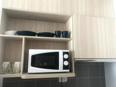 a microwave sitting on a shelf in a kitchen at Owow o2 in Bang Chak