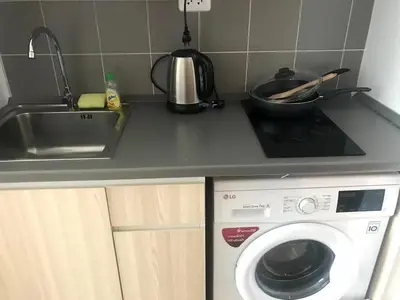 a kitchen counter with a washing machine and a sink at Owow o2 in Bang Chak