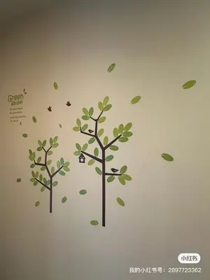 two trees with leaves and butterflies on a wall at Le Ram Hotel No windows in Bangkok