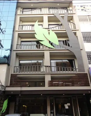 a building with a green leaf sign on it at Le Ram Hotel No windows in Bangkok