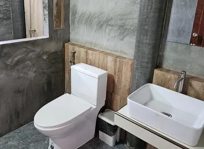 a bathroom with a white toilet and a sink at Nipatra Homestay in Ban Khlong Bang Sai