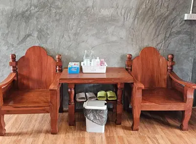 two wooden chairs sitting next to a wooden table with at Nipatra Homestay in Ban Khlong Bang Sai