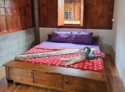 a bedroom with a bed with two swans on it at Nipatra Homestay in Ban Khlong Bang Sai