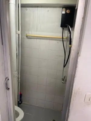 a bathroom with a shower with a toilet and a phone at รัตนากร แมนชั่น in Bang Su