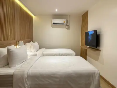 a hotel room with two beds and a flat screen tv at Winston Hotel in Bangkok