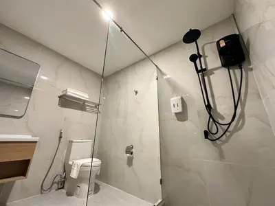 a bathroom with a shower with a toilet and a sink at Winston Hotel in Bangkok
