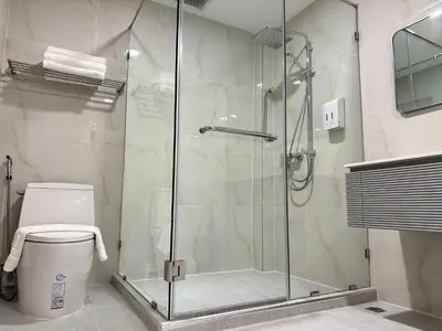 a shower stall in a bathroom with a toilet at Winston Hotel in Bangkok