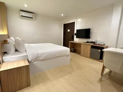 a hotel room with a bed and a television at Winston Hotel in Bangkok