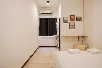 a small room with two beds and a window at XX GO INN Asiatique BKK Charoen krung- โกอินน์ เอเซียทีค เจริญกรุง in Godown