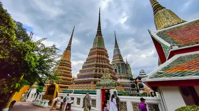 a group of pagodas with people standing in front of a building at XX GO INN Asiatique BKK Charoen krung- โกอินน์ เอเซียทีค เจริญกรุง in Godown