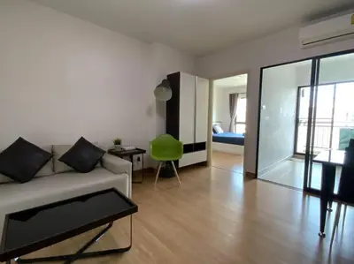 a living room with a couch and a green chair at Home at Sena in Bangkok