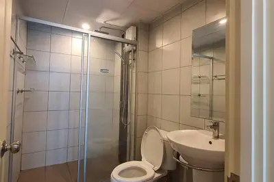 a bathroom with a shower and a toilet and a sink at Home at Sena in Bangkok