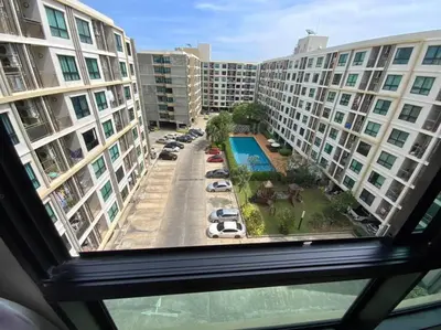 a view from a window of a parking lot with buildings at Home at Sena in Bangkok