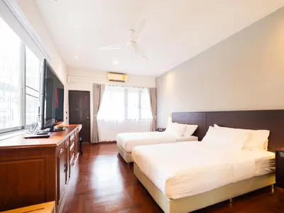 a hotel room with two beds and a flat screen tv at home22 Private Residence in Bangkok