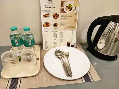 a white plate with a spoon and fork and water bottles at xx HD Yaowarat Road BKK in Samphanthawong