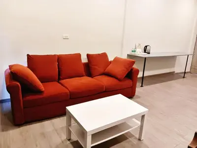 a living room with a red couch and a table at xx HD Yaowarat Road BKK in Samphanthawong